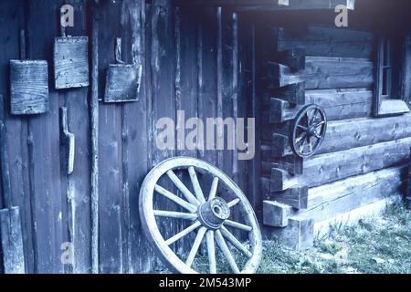 Vieux outils paysan accrochés sur un mur en bois sur une ferme animalière. Banque D'Images