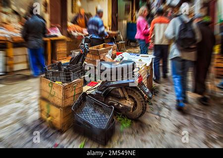 Mobylette garée entre des boîtes, foule anonyme dans le souk, effet zoom, image symbolique manque d'espace de stationnement, chaos, dynamique, Fes el Bali, Maroc Banque D'Images