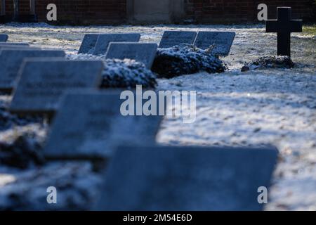 PRODUCTION - 15 décembre 2022, Saxe-Anhalt, Stendal : une croix se dresse à côté de tombes avec des plaques nominatives sur une tombe de guerre pour les soldats Wehrmacht tués pendant la Seconde Guerre mondiale Le bureau d'audit de l'État de Saxe-Anhalt a réprimandé la façon dont les autorités locales traitent les charniers de guerre. Selon une vérification de 14 municipalités, l'emplacement des tombes a été indiqué sur les plans et les conseils d'information dans seulement 15 des 52 cimetières. En outre, toutes les tombes n'étaient pas dans un état digne, ont critiqué les auditeurs (à dpa 'la Cour des comptes Etat réprimande les municipalités pour les tombes de guerre'). Photo: Klaus-Dietmar Gabb Banque D'Images