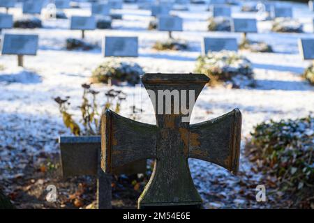 PRODUCTION - 15 décembre 2022, Saxe-Anhalt, Stendal : une croix en bois en forme de croix de fer se dresse devant les tombes avec des plaques nominatives sur une tombe de guerre pour les soldats Wehrmacht tués pendant la Seconde Guerre mondiale Le bureau d'audit de l'État de Saxe-Anhalt a réprimandé le traitement des tombes de guerre par les autorités locales. Seulement 15 des 52 cimetières avaient des cartes et des conseils d'information indiquant l'emplacement des tombes, selon une vérification de 14 municipalités. En outre, toutes les tombes n'étaient pas dans une condition digne, ont critiqué les auditeurs (à dpa 'Cour des comptes de Etat réprimandé munici Banque D'Images