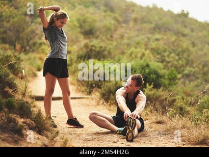 Prêt à travailler leurs muscles. un jeune couple sportif s'étirant avant une course à l'extérieur. Banque D'Images