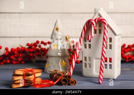 Composition avec de savoureuses cannes à sucre, des biscuits et un décor de Noël sur une table en bois de couleur Banque D'Images