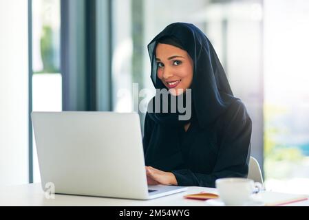 Productivité personnalisée. Portrait d'une jeune femme d'affaires musulmane utilisant un ordinateur portable à son bureau. Banque D'Images