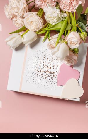 Carte de vœux de bonne Saint-Valentin, boîte-cadeau et magnifiques fleurs printanières sur fond rose clair. Saint-Valentin, Fête des femmes, Fête des mères Banque D'Images