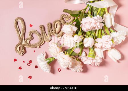 Le fond de la Saint-Valentin avec des lettres d'amour et de belles fleurs de printemps sur fond rose clair. Saint-Valentin, Fête des femmes, Fête des mères Banque D'Images