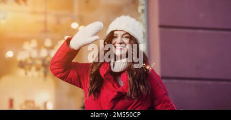 Jeune fille dans un rouge près de tenir des lumières Bengale. Noël est en train de se féliciter. Nouvelle année. Banque D'Images