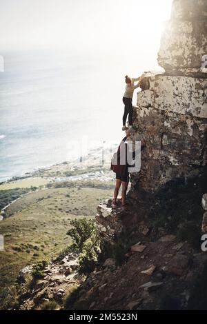 C'est ce que l'on a décidé d'atteindre le sommet. un groupe d'amis qui escaladez le flanc d'une montagne pendant une randonnée. Banque D'Images