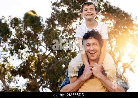 S'assurer que son boyhood est un plaisir. Portrait d'un père heureux portant son jeune fils sur ses épaules à l'extérieur. Banque D'Images