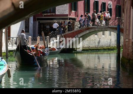 Vue sur le canal de Venise avec une télécabine en premier plan et plusieurs touristes traversant un pont, Venise, Italie Banque D'Images