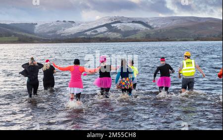 26 décembre 2022 - Un groupe de parents endurcis ont bravé les eaux froides de Semerwater dans les Yorkshire Dales pour recueillir des fonds pour le club de football junior de Hawes à Wensleydale. Semerwater se trouve à 820 pieds au-dessus du niveau de la mer et était plein d'eau de neige, coulant des coquillages environnants la semaine dernière. La température de l'air était de 1c, mais avec le refroidissement éolien, on avait l'impression que le thé était de -4c, du café était disponible pour les réchauffer ! Crédit : Wayne HUTCHINSON/Alamy Live News Banque D'Images