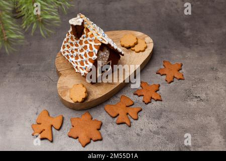 maison de pain d'épice avec biscuits. Gros plan sur un dessert maison sucré avec une décoration givrante sur fond gris Banque D'Images