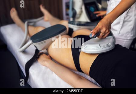 Femme qui obtient le traitement sur les fesses pour brûler la graisse, construire des muscles et enlever la cellulite. Salon de beauté professionnel Banque D'Images