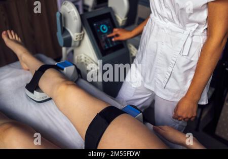 Femme qui obtient le traitement sur les fesses pour brûler la graisse, construire des muscles et enlever la cellulite. Salon de beauté professionnel Banque D'Images