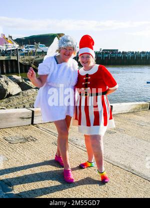 West Bay, Dorset, Royaume-Uni. 26th décembre 2022. Météo Royaume-Uni. Les courageux fêtards qui portent une robe festive vous plongent dans la mer froide depuis le port de West Bay à Dorset pour la baignade caritative de West Bay qui revient après un écart de trois ans en raison de la présence de covid lors d'une journée froide et ensoleillée. Crédit photo : Graham Hunt/Alamy Live News Banque D'Images