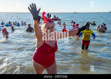 Jubilee Beach, Marine Parade, Southend on Sea, Essex, Royaume-Uni. 26th décembre 2022. Comme c'est devenu une tradition en bord de mer, un plongeon du lendemain de Noël a eu lieu dans l'estuaire de la Tamise à Southend on Sea, près de l'embarcadère de la ville, qui a permis de recueillir des fonds pour l'établissement national de la Royal Lifeboat local. Environ 400 personnes ont pris à l'eau qui était d'environ 6 degrés Celsius. Bon nombre des braves nageurs portaient une tenue de fête. Le bateau de sauvetage RNLI était à portée de main pour la sécurité. Femme senior quittant la mer Banque D'Images