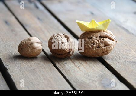 Concept créatif de leadership. Noix et un bateau en papier. Banque D'Images