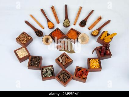 Une vue imprenable sur les épices indiennes savoureuses et épicées servies dans des boîtes en bois et des cuillères avec un mélange de thé masala Banque D'Images