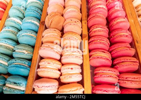 Vue en grand angle des plateaux de macarons colorés exposés sur un support en bois Banque D'Images