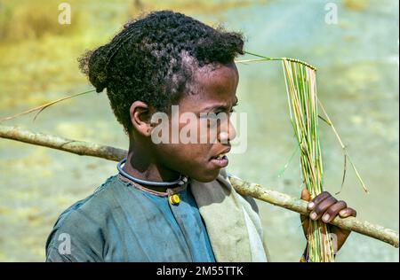 Éthiopie, 1970s ans, petite fille avec volant et portrait de bâton, région d'Oromia, Afrique de l'est, Banque D'Images