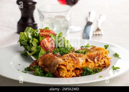 portion de lasagnes sur une assiette blanche Banque D'Images