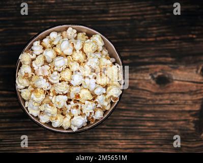 Vue de dessus de Popcorn dans un bol sur fond de bois sombre, en-cas de pop-corn sur une table avec espace pour les copies Banque D'Images