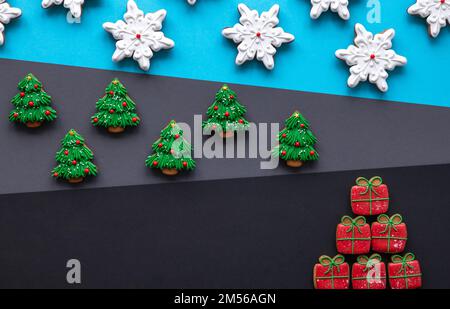 Pain d'épice de Noël recouvert de glaçage sur fond coloré, plat. Banque D'Images