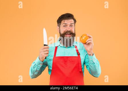 Le chef prépare le repas. Coupe sûre. Couper des légumes. Liste ultime des techniques de coupe que chaque chef devrait savoir. Homme barbu préparer la tomate. Salade fraîche Banque D'Images