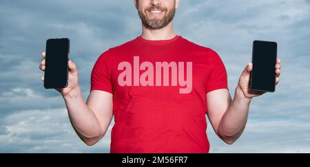 vue rognée de l'homme montrant l'application du téléphone sur fond ciel. homme montrant l'application du téléphone Banque D'Images