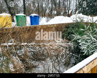 Tallinn, Estonie - 22 janvier 2022: Un grand conteneur à ordures dans une rue de la ville pour que les gens apportent leurs vieux arbres de Noël. Service municipal gratuit Banque D'Images