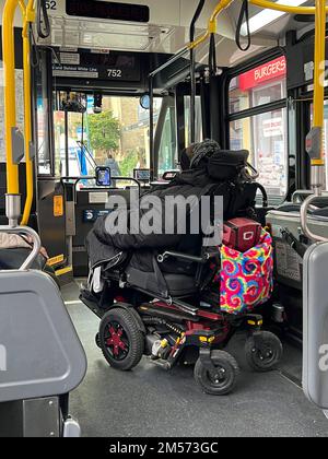 Femme en fauteuil roulant motorisé se préparant à sortir d'un bus MTA de la ville de New York équipé pour répondre aux besoins des personnes handicapées physiques. Banque D'Images