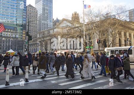 Les piétons traversent 42nd Street le long de 5th Avenue et la New York public Library en arrière-plan pendant la période des fêtes de Noël. Banque D'Images