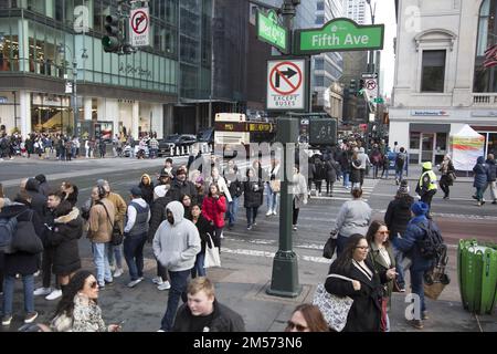 La foule se trouve au coin de 5th Avenue et 42nd Street une semaine avant Noël dans le centre-ville de Manhattan, New York. Banque D'Images