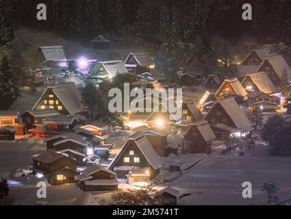 Des toits de chaume enneigés illuminés la nuit à Shirakawago Banque D'Images