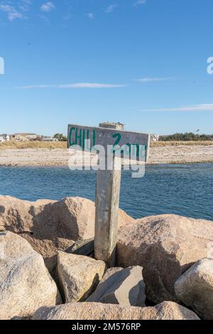 Photo relaxante, image d'un panneau en bois avec poste sur une plage avec de l'eau qui dit ZONE DE REFROIDISSEMENT. Banque D'Images