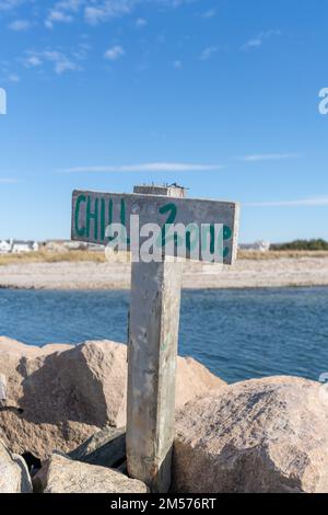 Photo relaxante, image d'un panneau en bois avec poste sur une plage avec de l'eau qui dit ZONE DE REFROIDISSEMENT. Banque D'Images