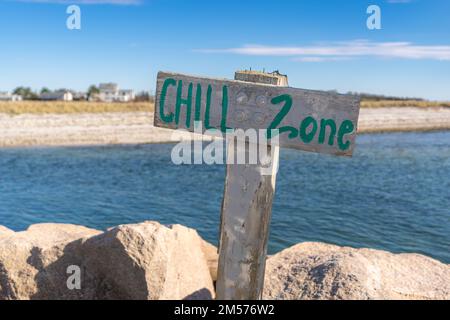 Photo relaxante, image d'un panneau en bois avec poste sur une plage avec de l'eau qui dit ZONE DE REFROIDISSEMENT. Banque D'Images