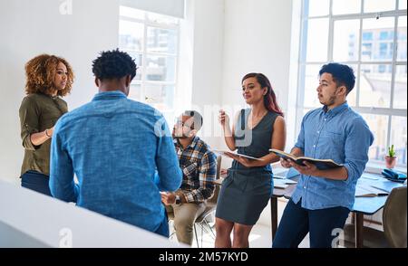 C'est une agence orientée équipe. une équipe de jeunes entrepreneurs ayant une discussion dans un bureau moderne. Banque D'Images