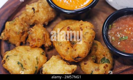 en-cas indiens traditionnels, vada et chutneys frits et croustillants dans une assiette de service Banque D'Images