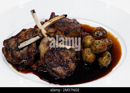 côtelettes d'agneau grillées marinées aux épices ou râtelier avec des pommes de terre de bébé et de la sauce rôtie Banque D'Images