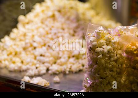 le pop-corn est conservé au comptoir pour la vente dans des paquets de plastique transparent. en-cas populaire pendant le visionnement du film. pile de pop-corn blanc cuit au beurre. Banque D'Images