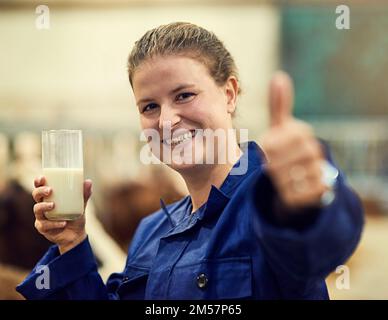 Rien de plus frais. Portrait d'un fermier heureux donnant un pouce vers le haut signe tout en appréciant un verre de lait frais. Banque D'Images