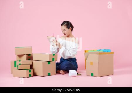 Jeune belle femme asiatique se prépare à envoyer des produits par commande à ses costomers Banque D'Images