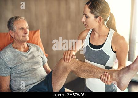 Shes un expert sur la façon dont le corps fonctionne et se déplace. un homme âgé traité par un physiothérapeute. Banque D'Images