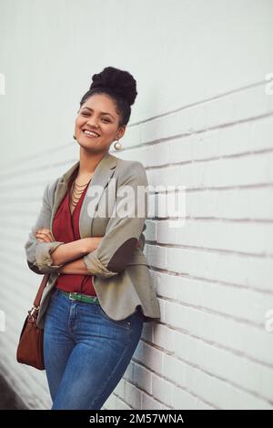 La vie ne devrait pas être plus belle. Portrait d'une belle jeune femme debout contre un mur de briques. Banque D'Images