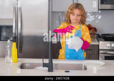 Portrait du nettoyage de l'enfant dans le kithen à la maison, la croissance du concept, le développement, les relations familiales. Banque D'Images