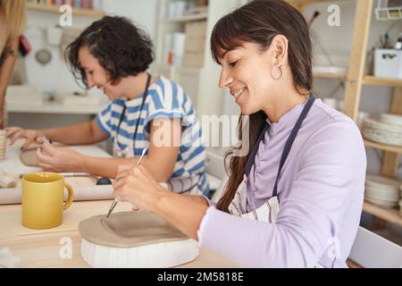 Femmes faisant de la poterie à la main dans une classe de poterie. Concept d'artisanat et d'hobbies. Banque D'Images