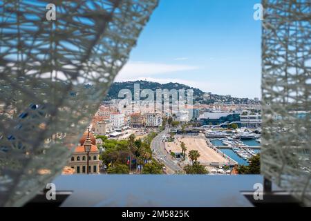 Une vue encadrée par une structure sur le port de plaisance de Cannes depuis le quartier de Suquet. Pris un jour de printemps ensoleillé. Banque D'Images