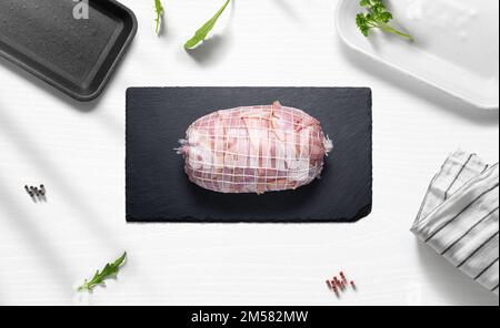 Rôti de bœuf au bacon sur une surface plate d'une cuisine avec divers articles du dessus Banque D'Images