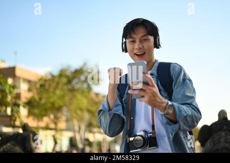 Surpris heureux homme regardant sur le téléphone mobile et se sentant excité, criant avec joie célébrer la victoire succès Banque D'Images