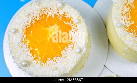 Petits gâteaux à l'orange et à la noix de coco sur fond bleu. Banque D'Images